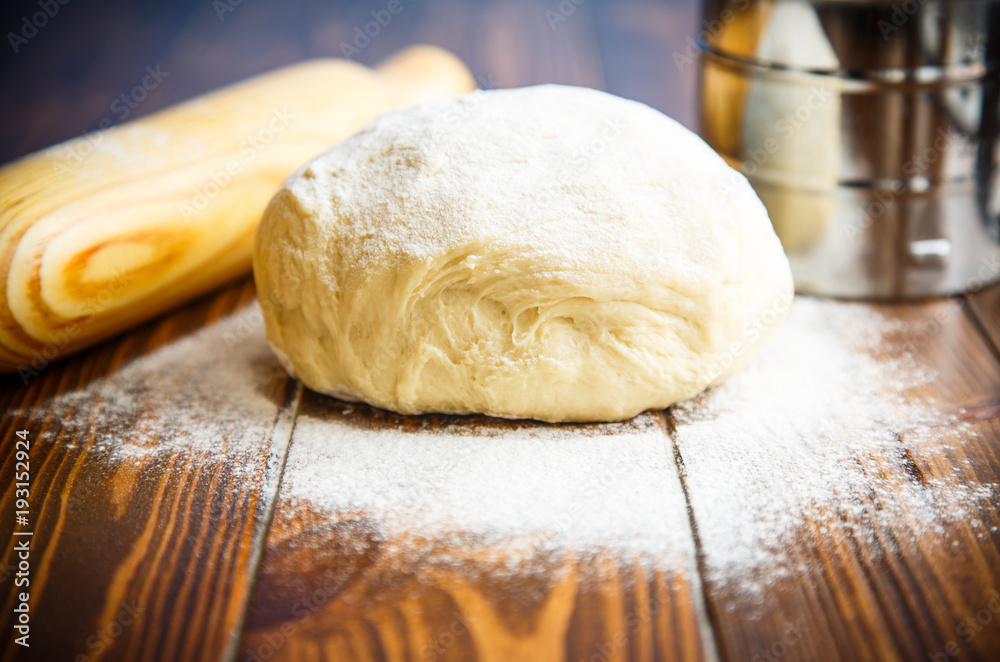 fresh raw dough with a rolling pin fresh raw dough with a rolling pin