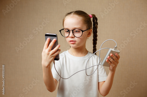 Cute little girl using modern smartphone photo