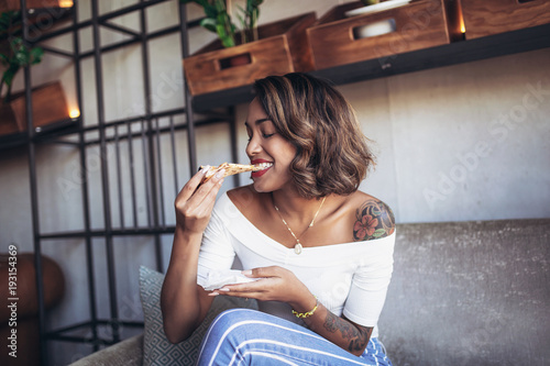 Obraz na płótnie Young cuban woman eating pizza in cafe