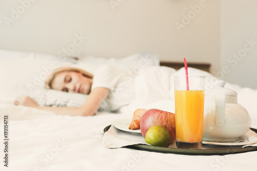 Closeup of breakfast in front of sleeping woman photo