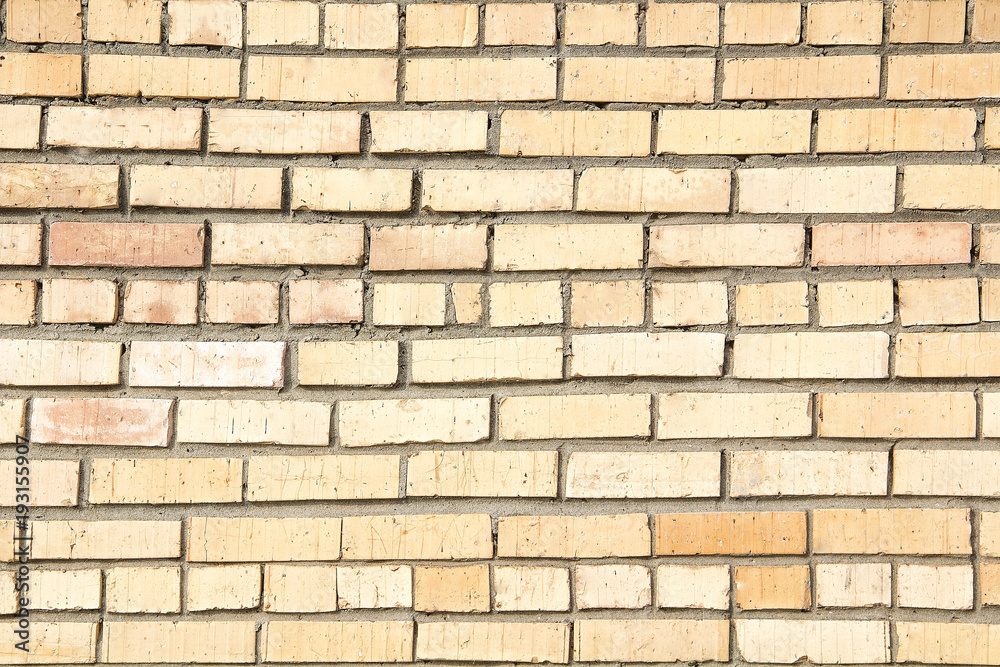 The texture of the old brick wall with concrete seams on a clear sunny day.