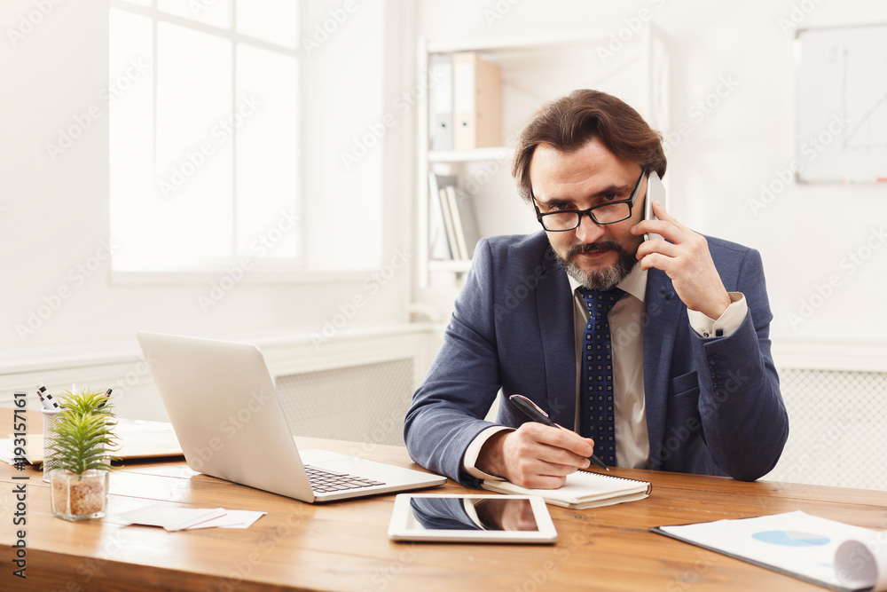 Concentrated businessman talking on mobile phone Concentrated businessman talking on mobile phone