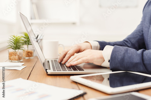 Unrecognizable businessman typing on laptop