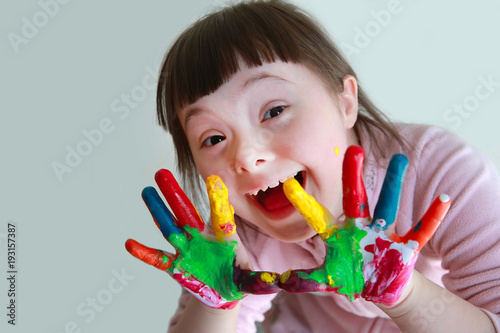 Cute little girl with painted hands. Isolated on grey background.