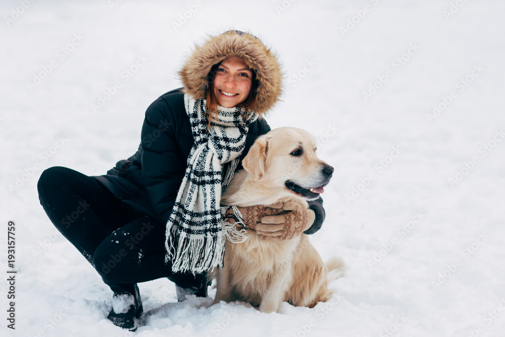 Image of smiling woman with dog in winter park