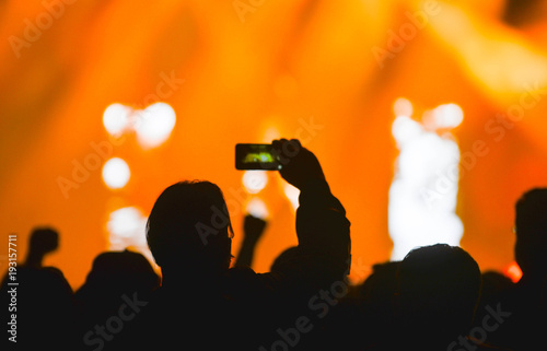 Silhouette hands of audience crowd people use smart phones enjoying the concert. Concert light show