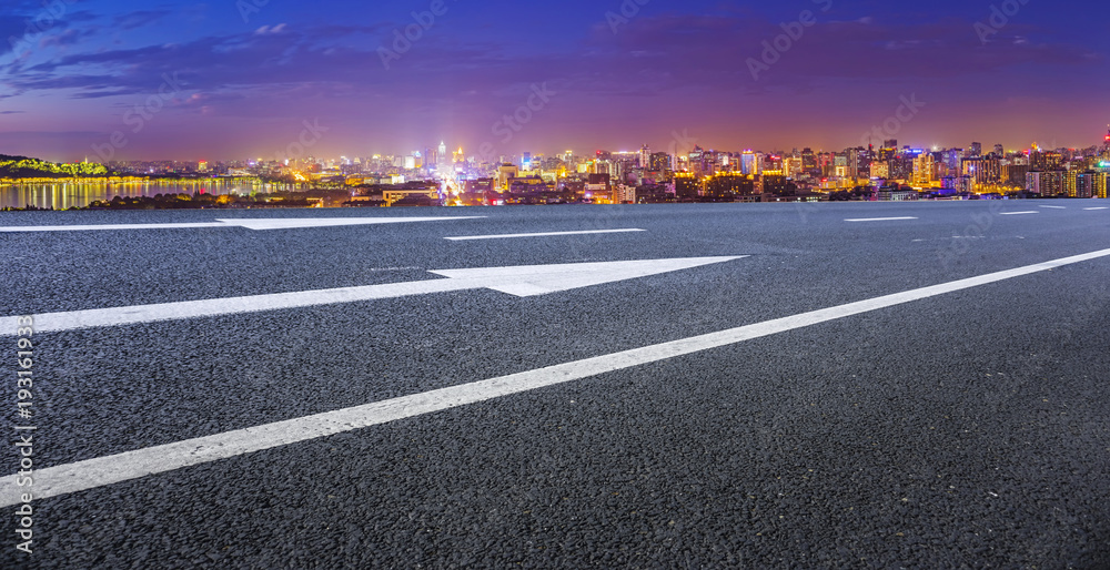 View of the skyline of Hangzhou urban architectural landscape from square floor tiles and empty asphalt pavement View of the skyline of Hangzhou urban architectural landscape from square floor tiles and empty asphalt pavement