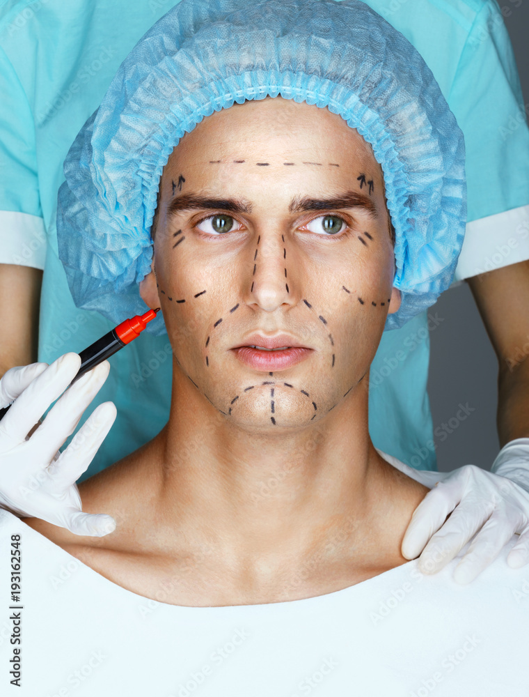 Man in medical hat before plastic surgery with surgical lines on face