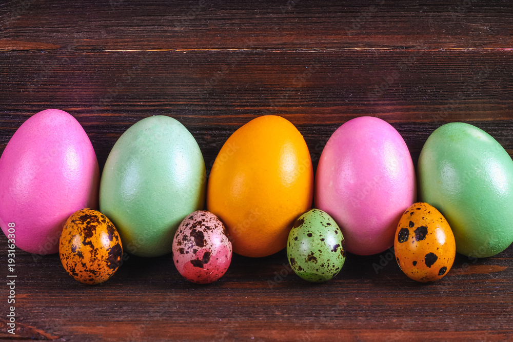 Multicolored easter eggs on a brown wooden table.