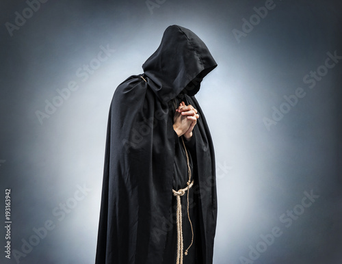 Silhouette of a praying monk, folded hands in prayer. Photo of monk at prayer. Concept for faith, spirituality and religion