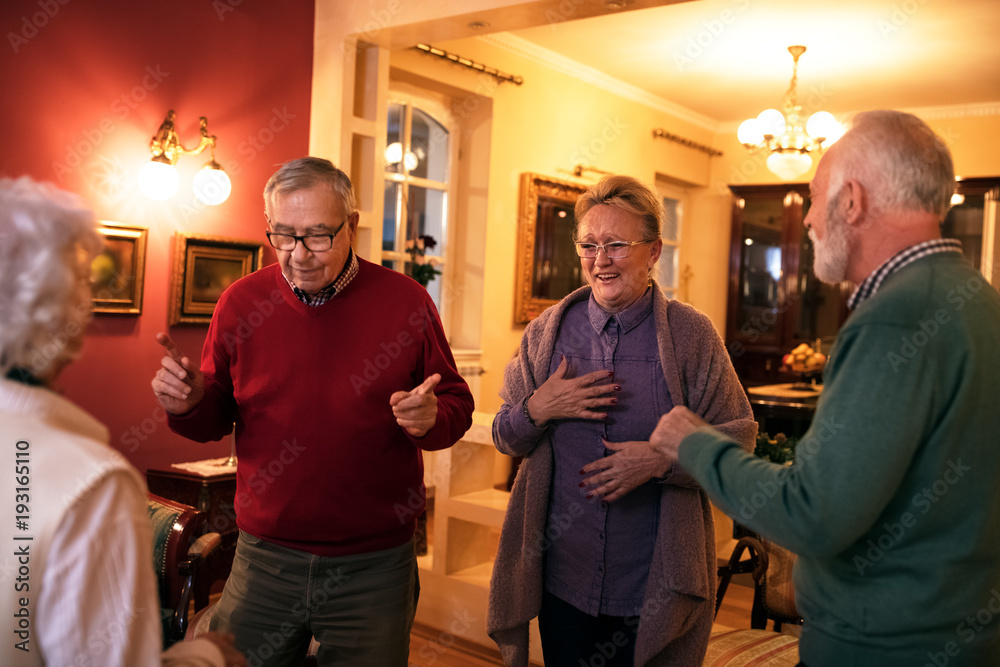 Obraz premium Funny senior people smiling and dancing at home party