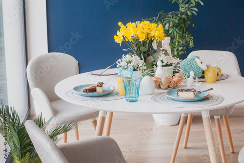 Pastel Easter table decoration on navy blue wall photo