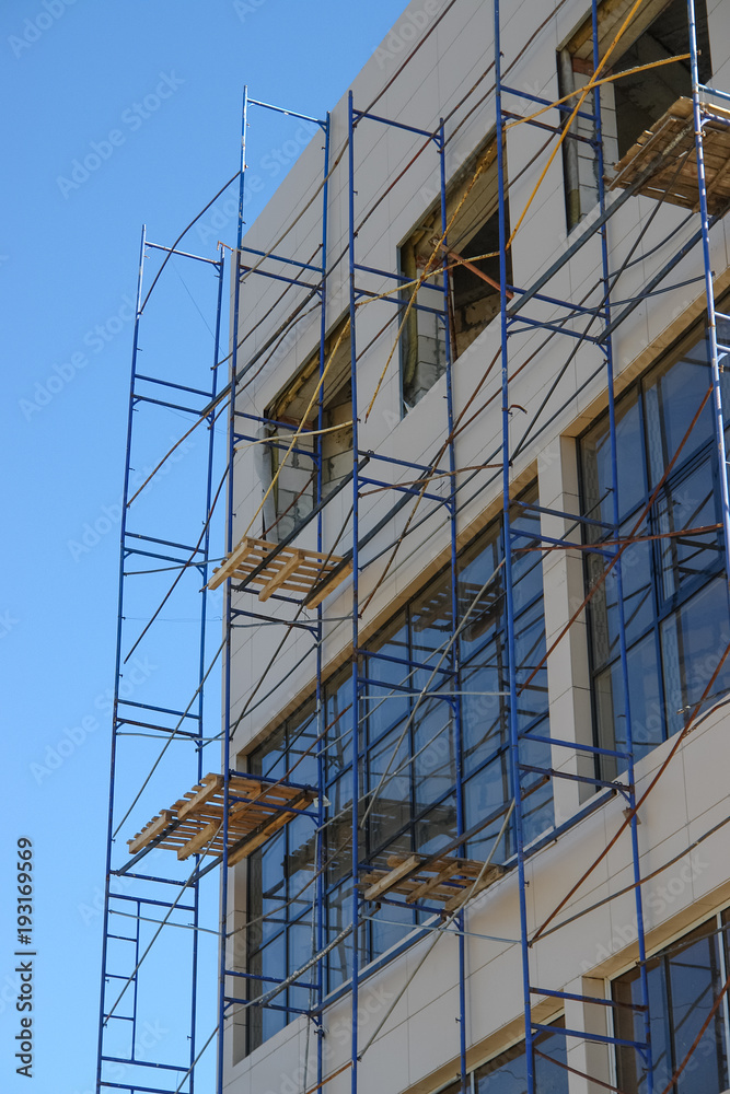 Scaffolding round building with sky at background Scaffolding round building with sky at background
