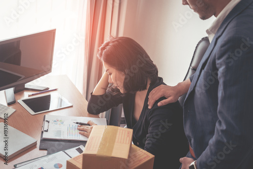 Male boss is consolidating stressed out business woman photo