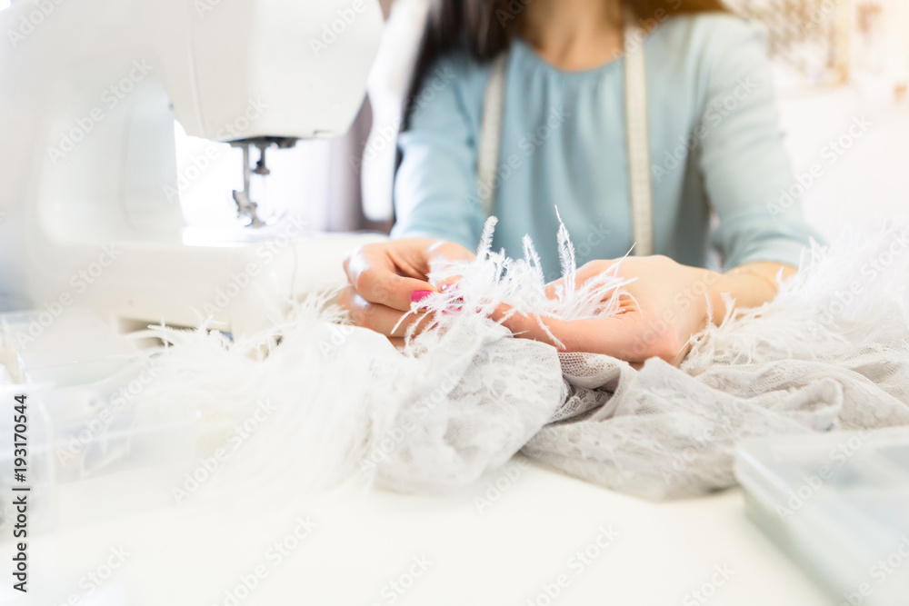 Close up of sewing process, the sewing machine with seamstress women hands Close up of sewing process, the sewing machine with seamstress women hands