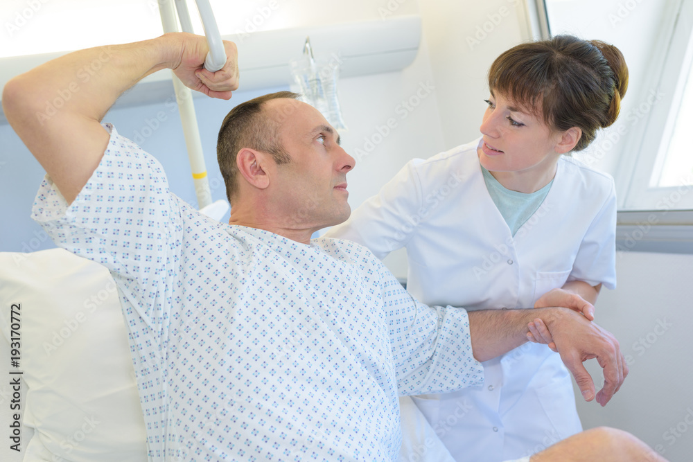 Fototapeta premium patient lying on bed while nurse talking to him