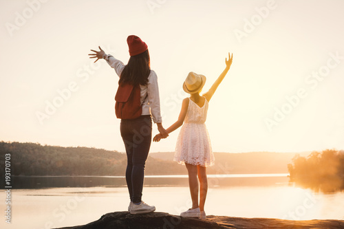 Happy mother and daughter looking at the sky during sunset, Relax time on holiday concept travel,selective and soft focus,color of hipster style