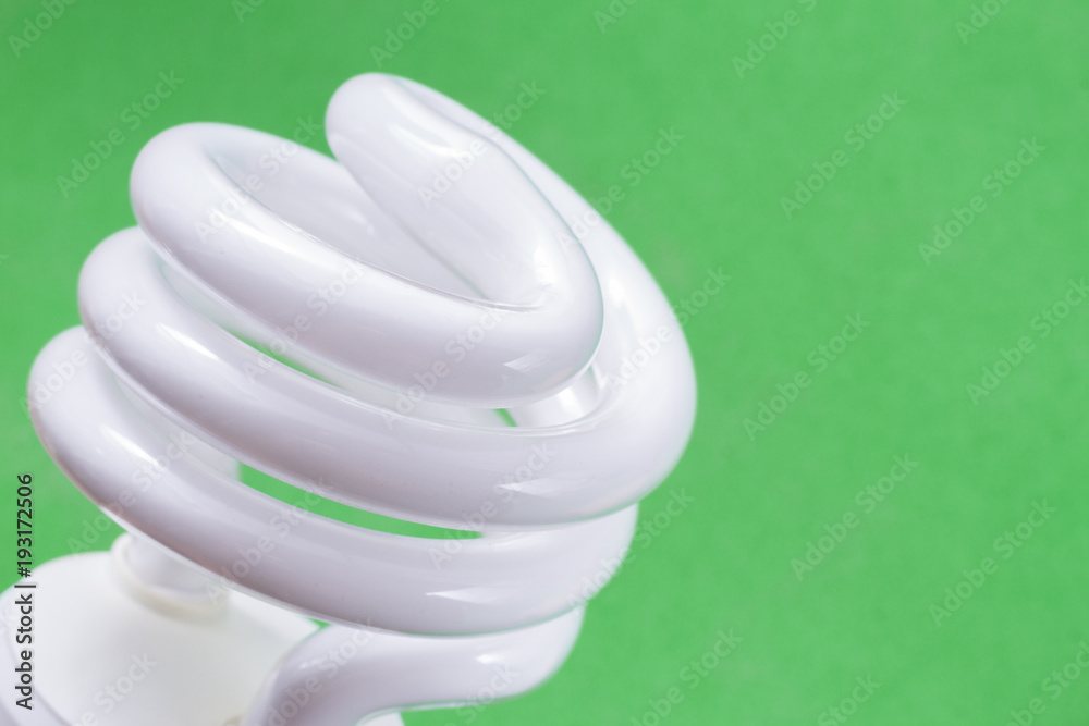 Fluorescent light bulb on green background, technology that contains