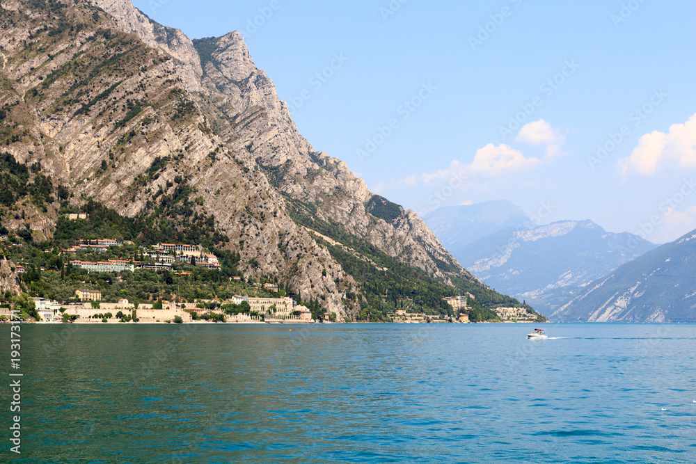 Lake Garda and mountain panorama with boat in Limone, Italy