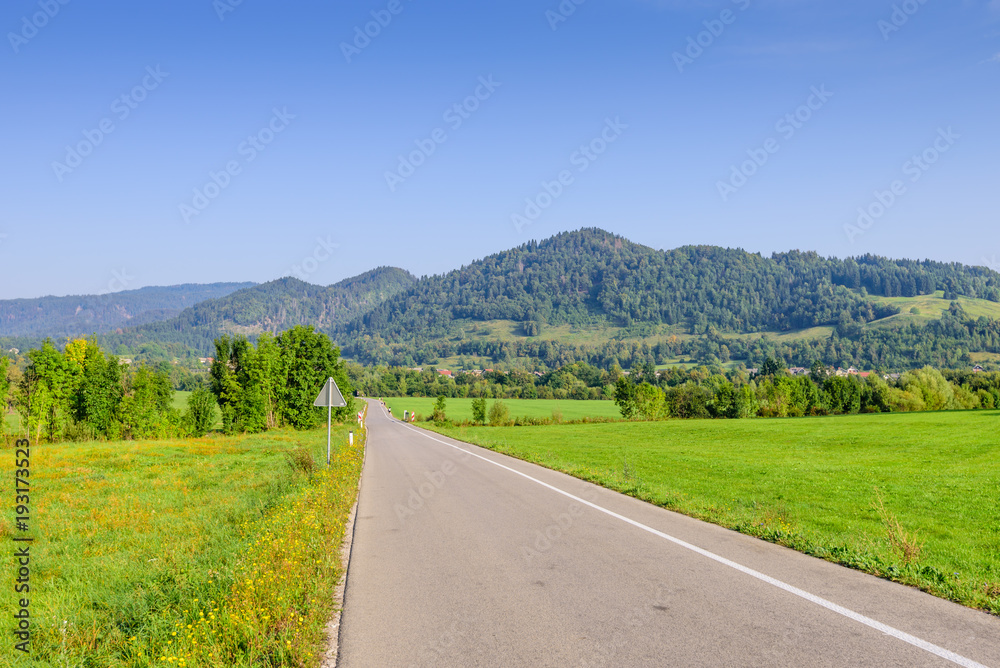 Pictorial field and an asphalt road on the background of mountain peaks, Bled, Slovenia. Pictorial field and an asphalt road on the background of mountain peaks, Bled, Slovenia.