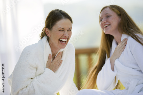 Smiling mother and daughter wearing bathrobes
