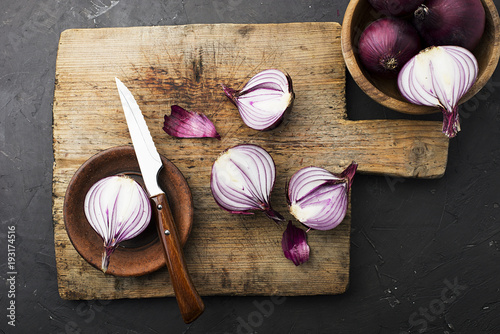 Red onions on an old vintage wooden cutting board with a knife and thyme. Top View. photo