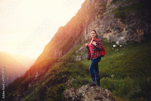 Traveling woman with backpack looking river and mountains, sunny day