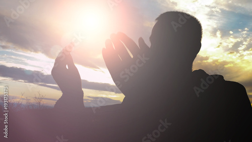 Canvas Print Silhouette of young muslim man praying during sunset