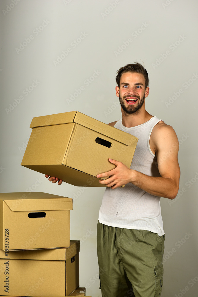 Moving in concept: guy with carton on grey background Moving in concept: guy with carton on grey background