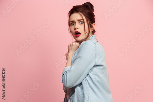 Portrait of the scared woman on pink photo