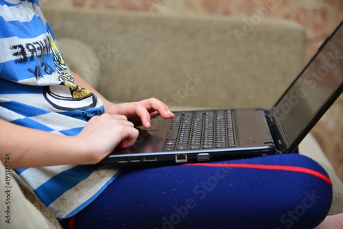Photography Boy working with laptop sitting and diva, close-up
