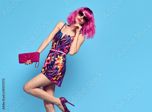 Gorgeous Fashion woman with Pink Hair, Trendy Sunglasses. Young female model in Stylish Spring Outfit Posing in Studio. Glamour Beautiful Lady. Party fashionable Hairstyle