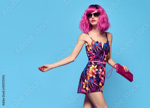 Fashionable female model with Pink Hair, Trendy Sunglasses. Stylish Party Glamour Outfit. Young Beautiful European girl Posing in Studio. Gorgeous fashion woman