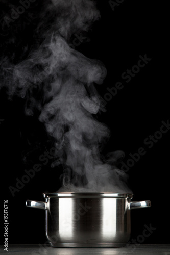 Steaming pot on black background