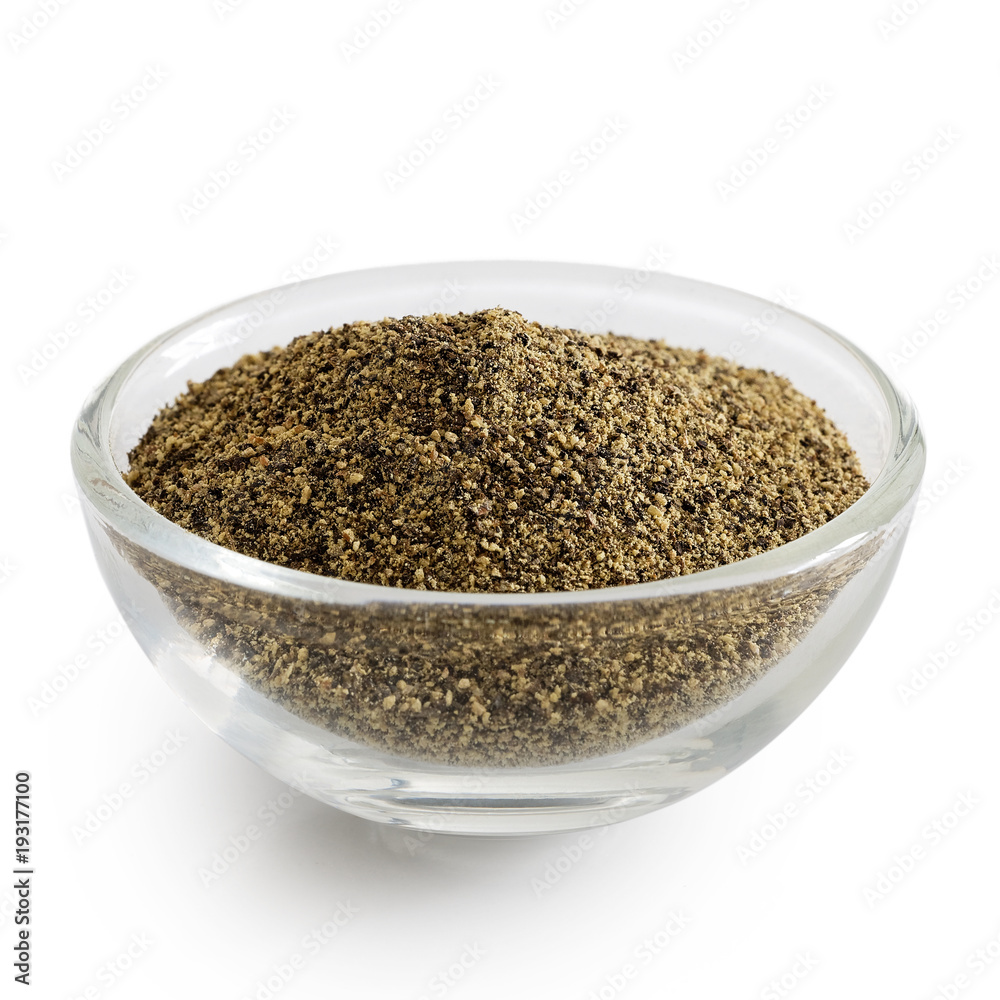 Finely ground black pepper in glass bowl isolated on white.