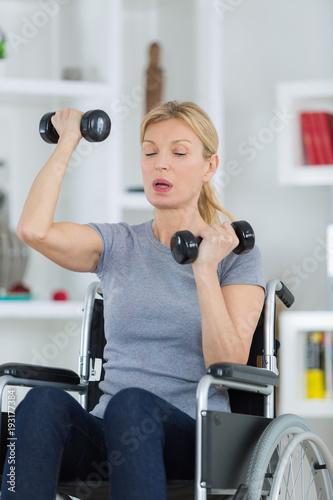 happy disabled person doing exercises with dumbbells