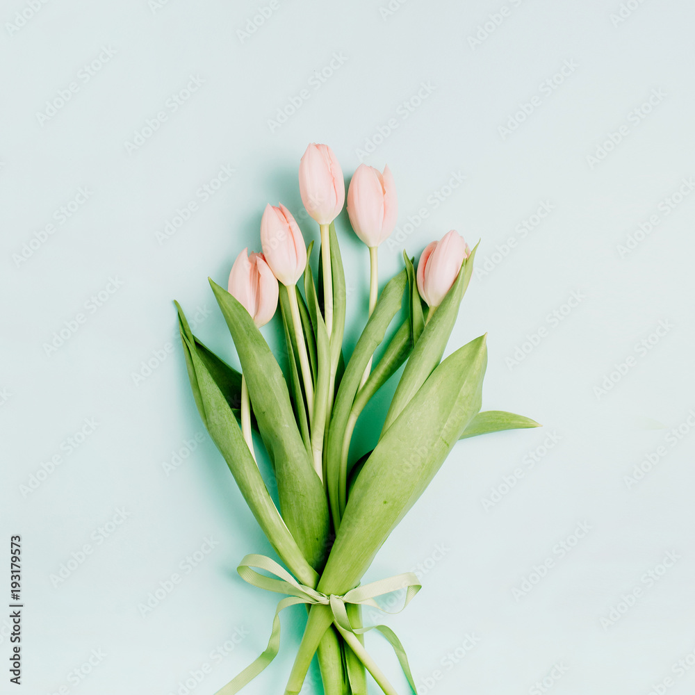Pink tulip flowers bouquet on pale blue background. Flat lay, top view. Spring floral concept. Pink tulip flowers bouquet on pale blue background. Flat lay, top view. Spring floral concept.