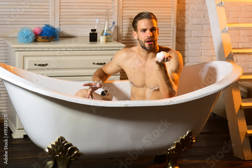 Sexuality and relaxation concept: bearded macho in bathroom