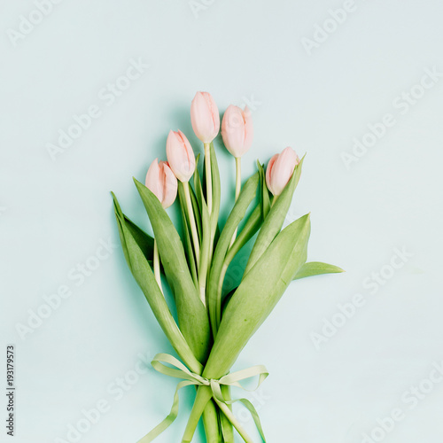 Pink tulip flowers bouquet on pale blue background. Flat lay  top view. Spring floral concept.