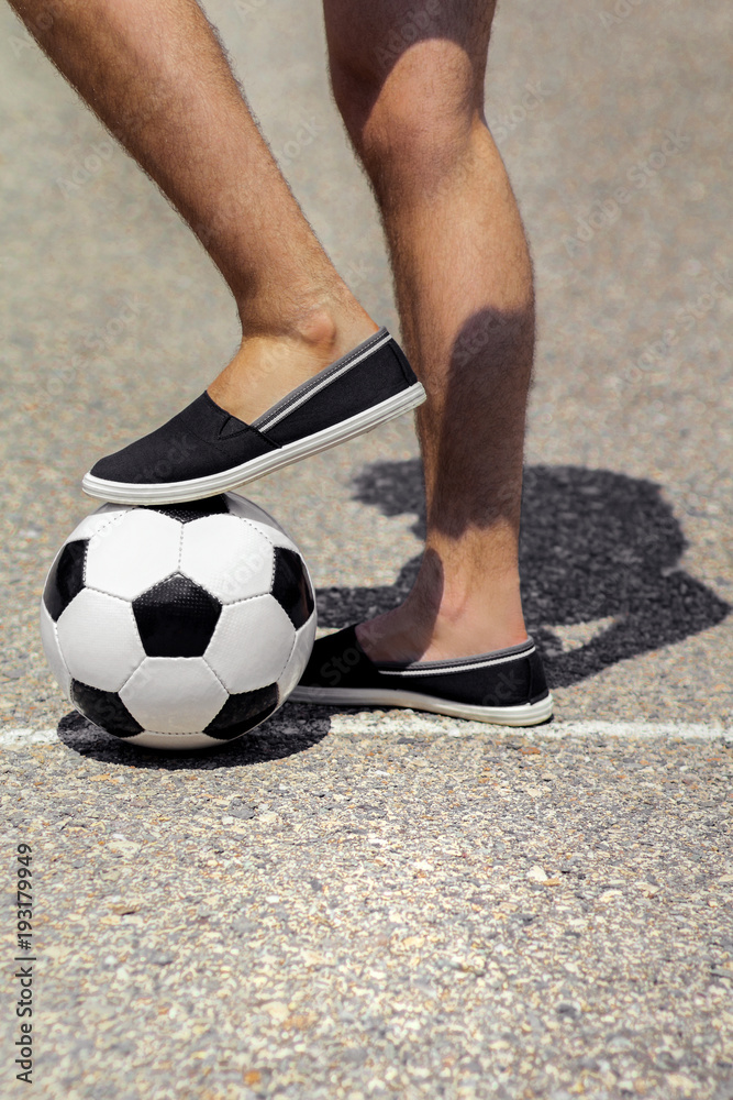 Men's legs next to a soccer ball