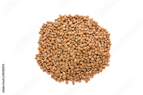 A pile of brown lentils on a white background. Brown lentils piled with a slide on a white background.
