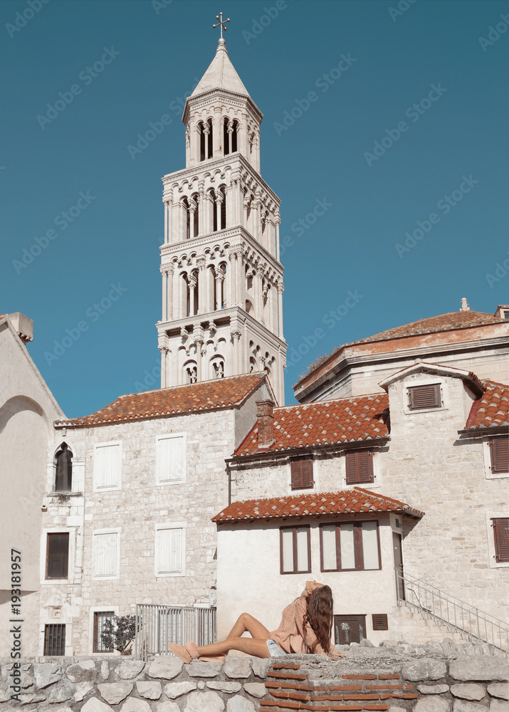 Girl tourist enjoying and sightseeing Marble ancient roman architecture in city center of town Split, view cathedral Saint Domnius and bell tower landmarks, Croatia.