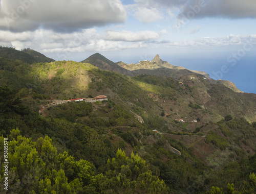 view on Monte Taborno with green hills, houses and blue sky white clouds in anaga mountain, tenerife canary island spain
