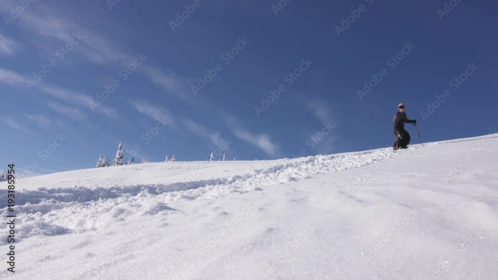Low angle, skier trudges up mountain in British Columbia Low angle, skier trudges up mountain in British Columbia