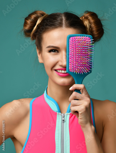 Young happy woman close eyes with pink and blue big hair comb brush smiling 