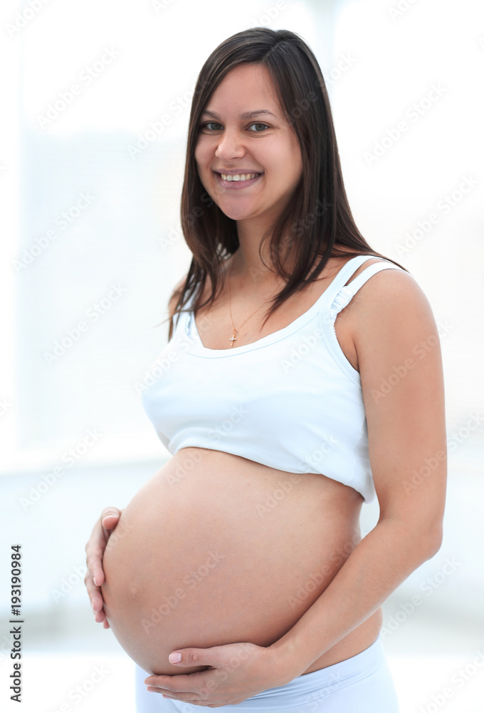 closeup of a pregnant woman putting her hands on her tummy. closeup of a pregnant woman putting her hands on her tummy.