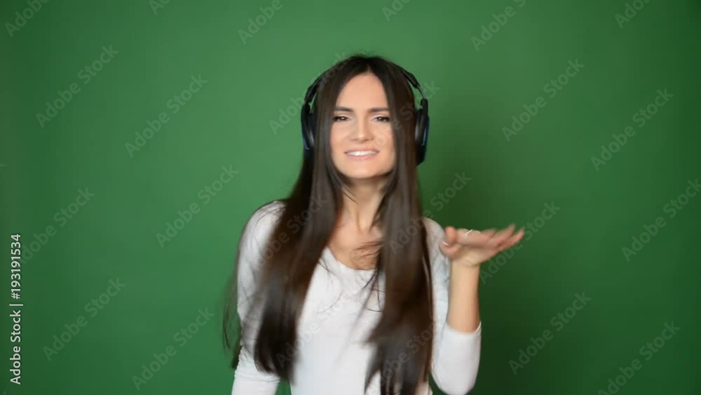 beautiful attractive girl dancing with headphones, music and fuan concept. Singing and smiling isolated on green beautiful attractive girl dancing with headphones, music and fuan concept. Singing and smiling isolated on green