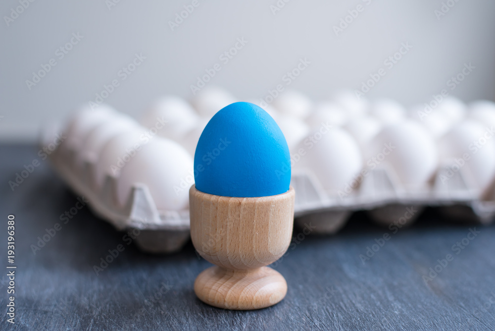 One blue egg and a cardboard box with eggs One blue egg and a cardboard box with eggs