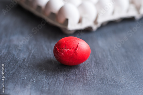 Red broken egg and cardboard box with eggs