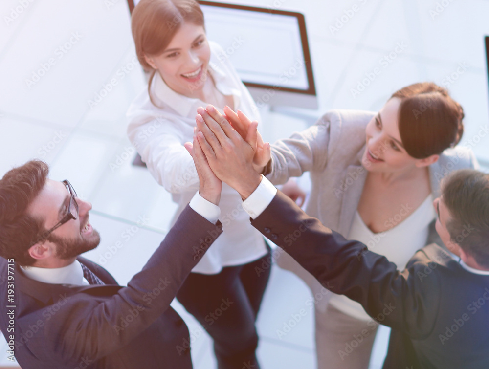 successful business team giving each other a high-five, standing in the office successful business team giving each other a high-five, standing in the office